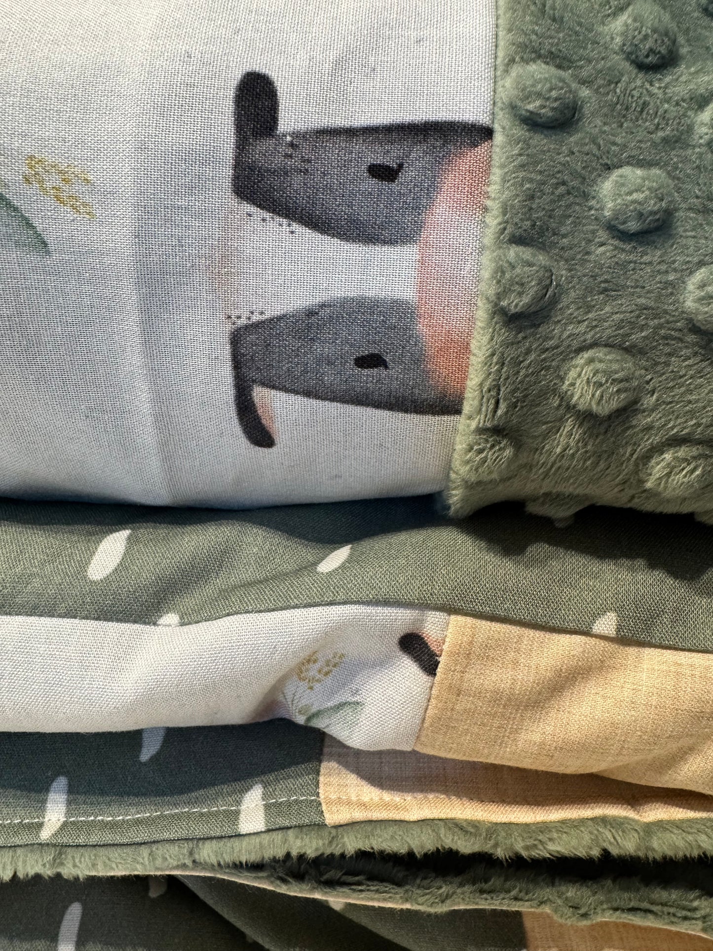 Prête à partir, Couverture de style courtepointe légèrement matelassée, vaches noires et blanches. Endos doux en minky vert olive
