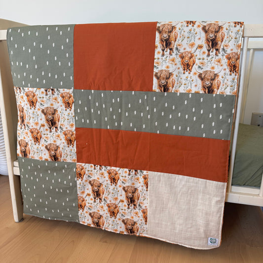 Prête à partir, Couverture de style courtepointe légèrement matelassée, vaches highland fleurie.  Endos doux en minky orange