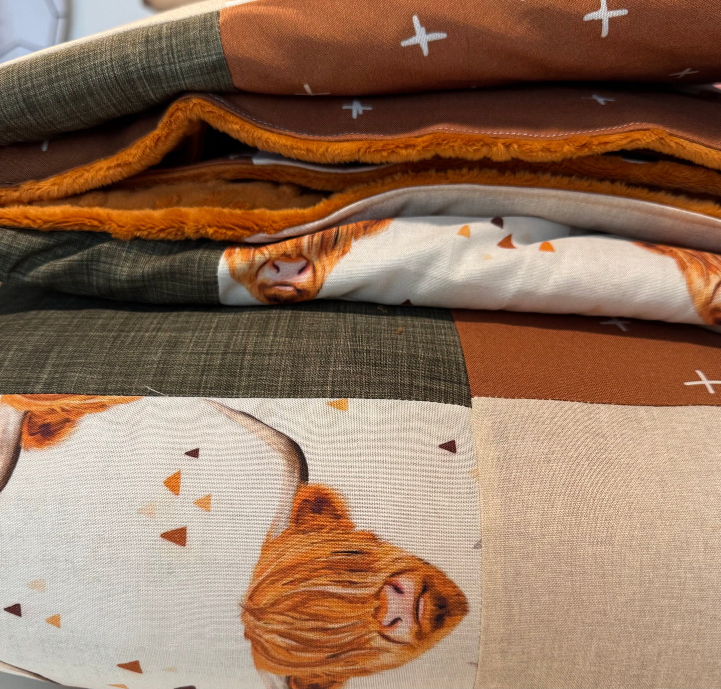 Prête à partir, Couverture de style courtepointe légèrement matelassée, vaches highland. Endos doux en minky orange