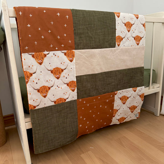 Prête à partir, Couverture de style courtepointe légèrement matelassée, vaches highland.  Endos doux en minky orange
