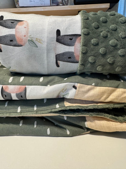 Prête à partir, Couverture de style courtepointe légèrement matelassée, vaches noires et blanches.  Endos doux en minky vert olive