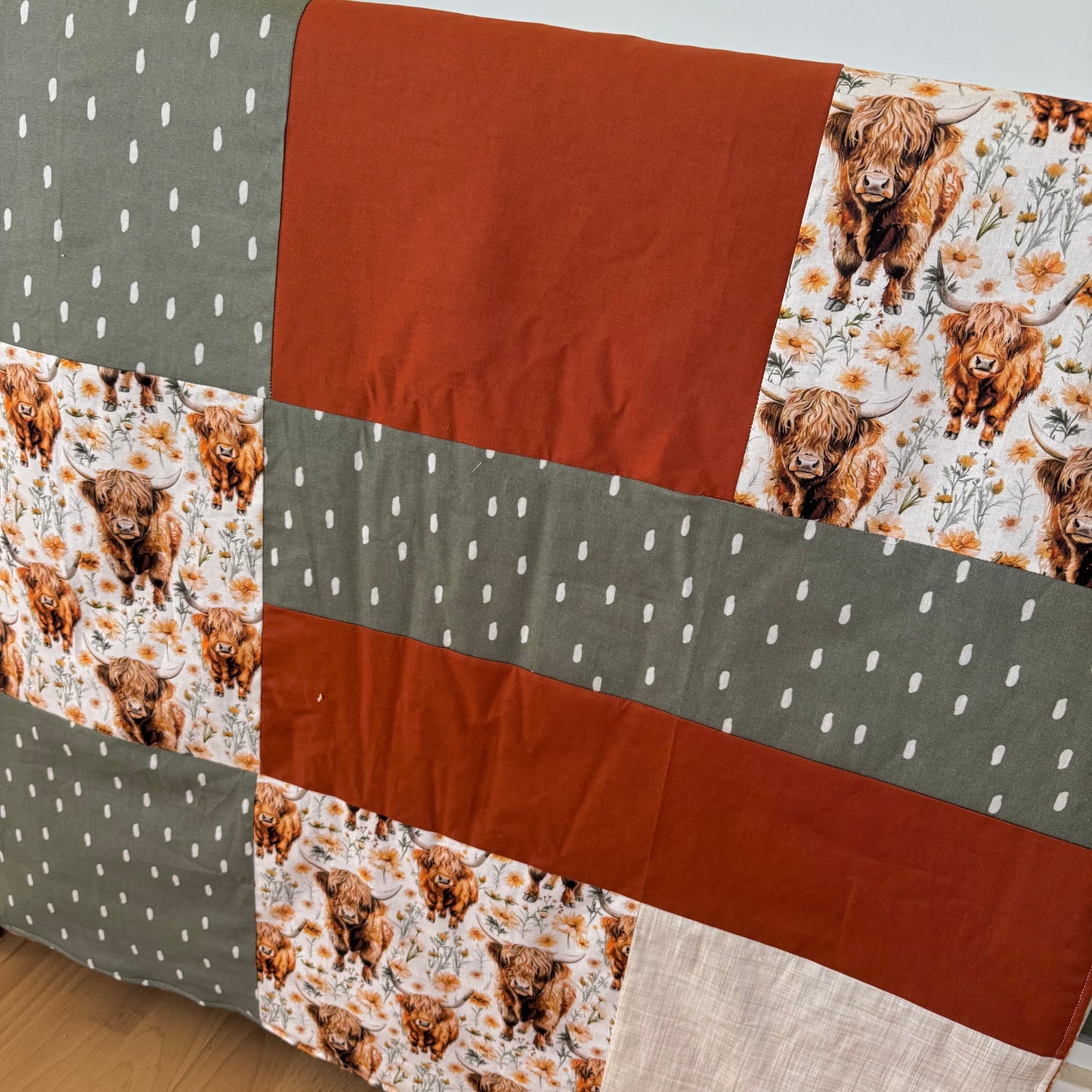 Prête à partir, Couverture de style courtepointe légèrement matelassée, vaches highland fleurie.  Endos doux en minky orange