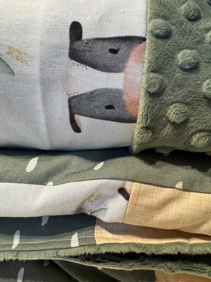 Prête à partir, Couverture de style courtepointe légèrement matelassée, vaches noires et blanches.  Endos doux en minky vert olive