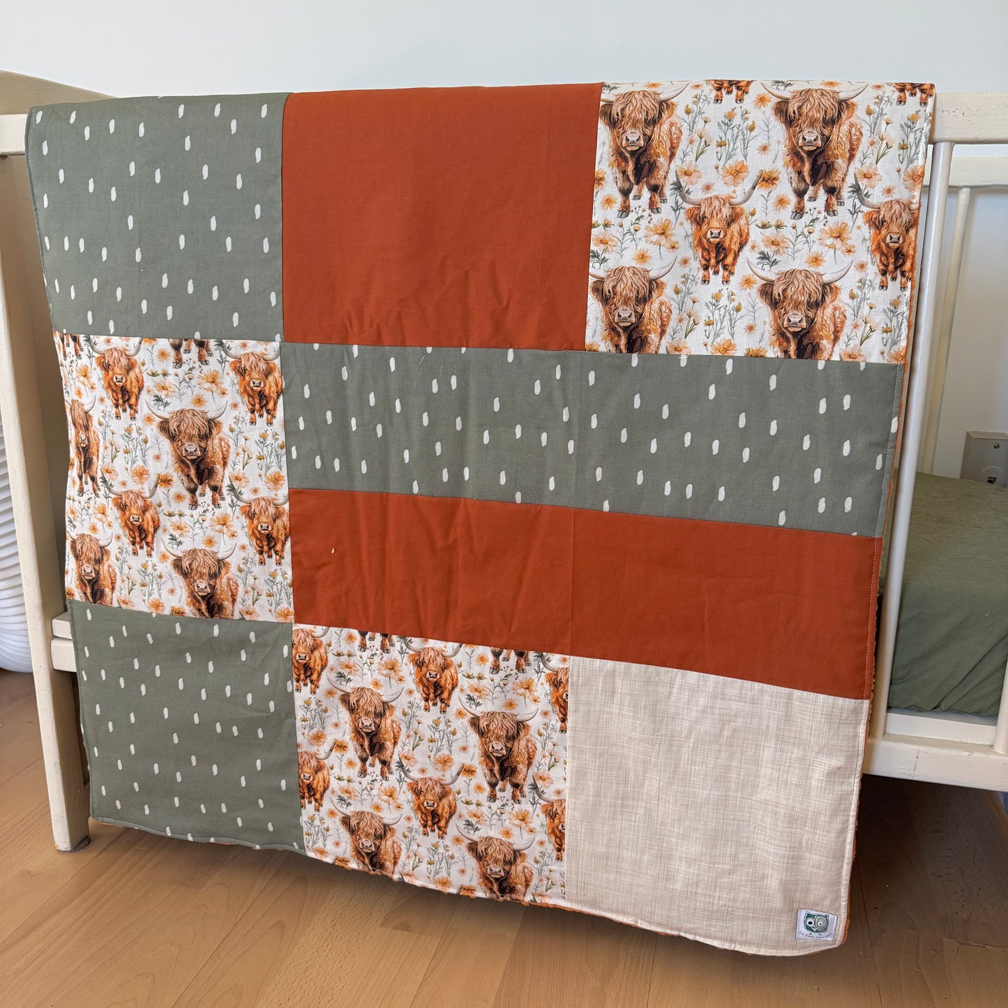 Prête à partir, Couverture de style courtepointe légèrement matelassée, vaches highland fleurie.  Endos doux en minky orange