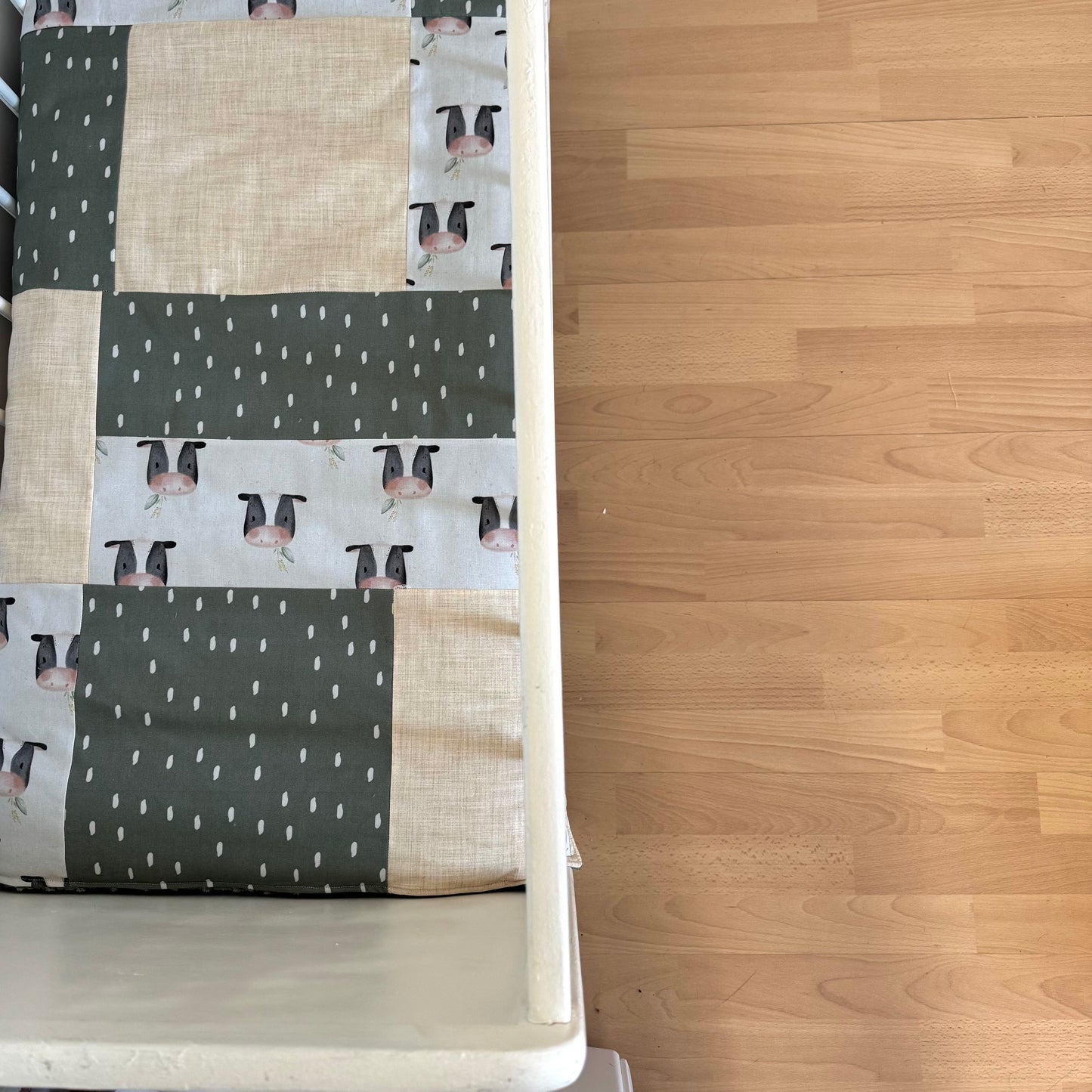 Prête à partir, Couverture de style courtepointe légèrement matelassée, vaches noires et blanches.  Endos doux en minky vert olive