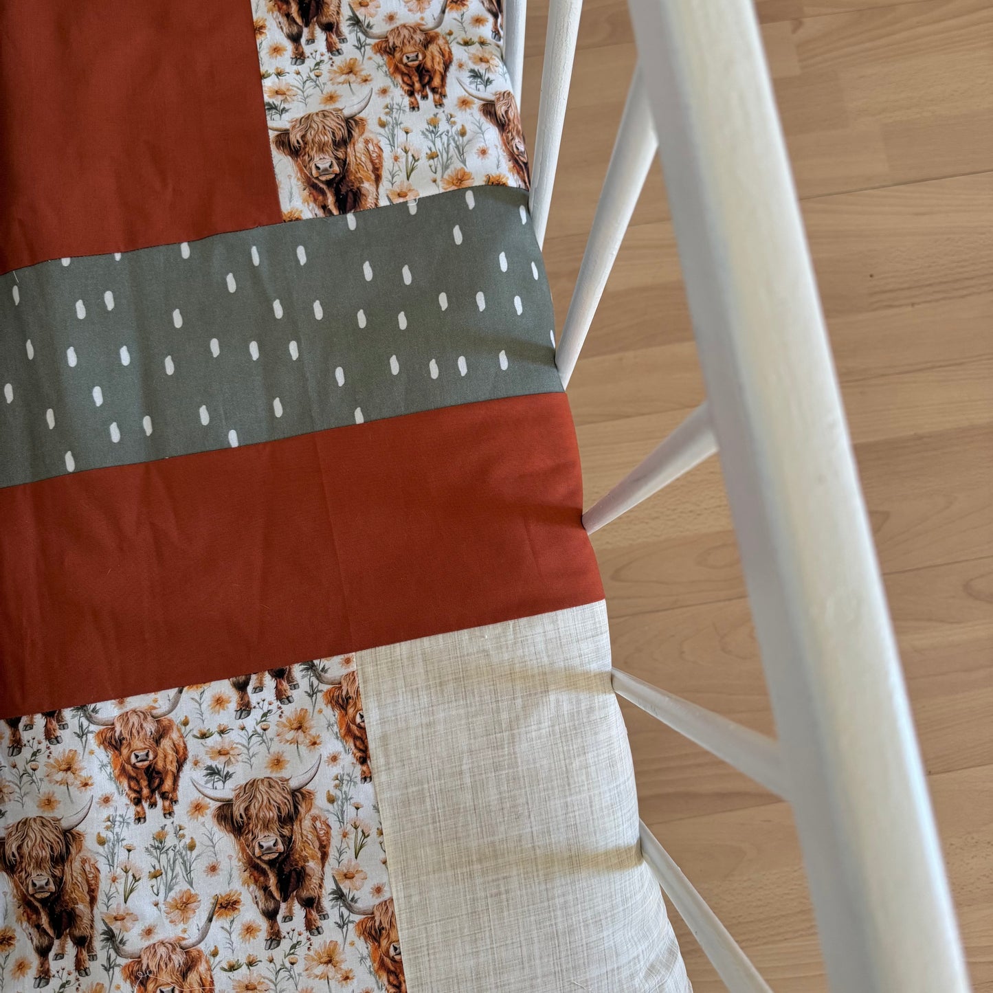 Prête à partir, Couverture de style courtepointe légèrement matelassée, vaches highland fleurie.  Endos doux en minky orange